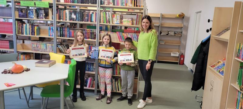 Biblioteka szkolna. Na zdjęciu Pani Ola z laureatami konkursu.