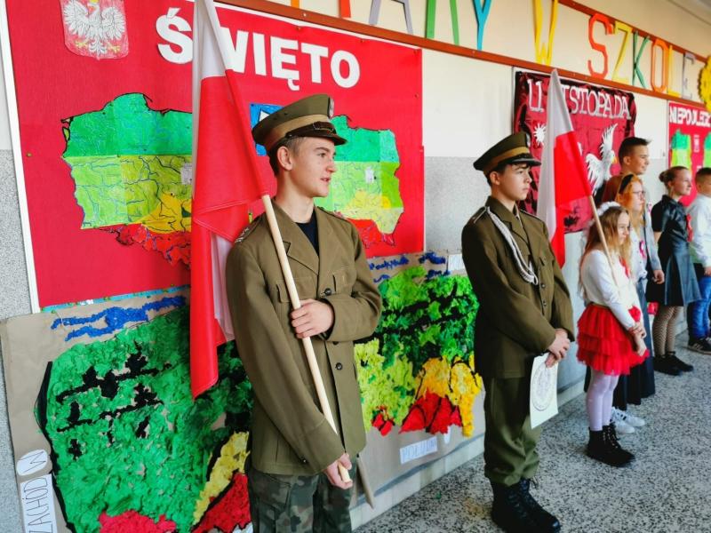 Na zdjęciu uczniowie klasy siódmej przebrani za żołnierzy, oraz uczniowie innych klas w strojach galowych, Fragment części artystycznej apelu o niepodległości.