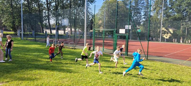 Uczniowie klas 1-3 podczas biegu w piżamach przy szkolnym boisku