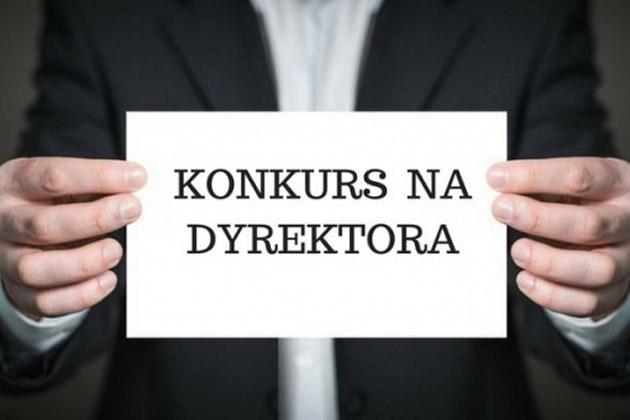 Pan trzymający kartkę z napisem konkurs na dyrektora.