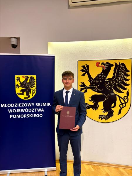 Tomasz Blazer trzymający dokument z nominacją.