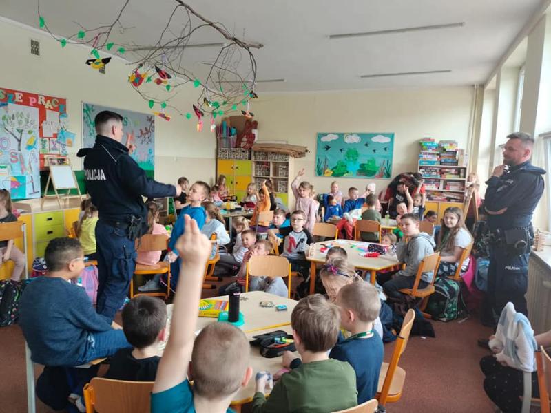 Policjanci prowadzą zajęcia na świetlicy szkolnej z zakresu tematyki o bezpieczeństwie w ruchu drogowym.