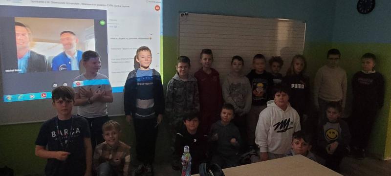 Uczniowie przy wyświetlaczu tablicy interaktywnej podczas spotkania online z astronautą