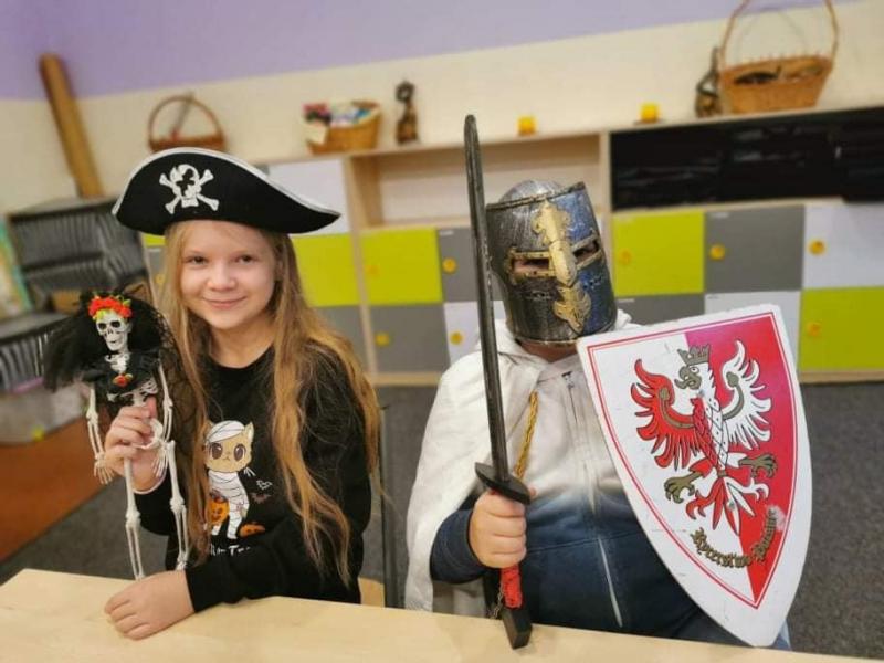 Dwoje uczniów przebranych za pirata i średniowiecznego rycerza pilnują szkolnej ławki