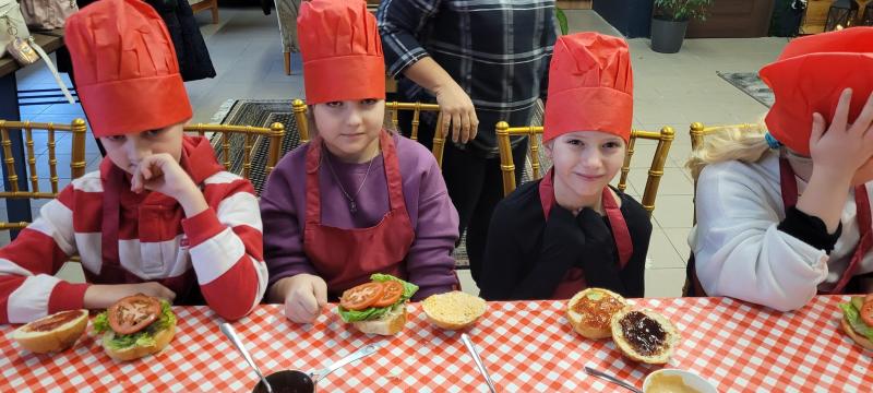 Uczniowie klasy trzeciej w restauracji podczas warsztatów kulinarnych - uczniowie uczą się przygotowywać hamburgery.