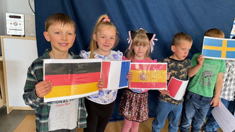 Dzieci prezentują flagi państw członkowskich Unii Europejskiej.
