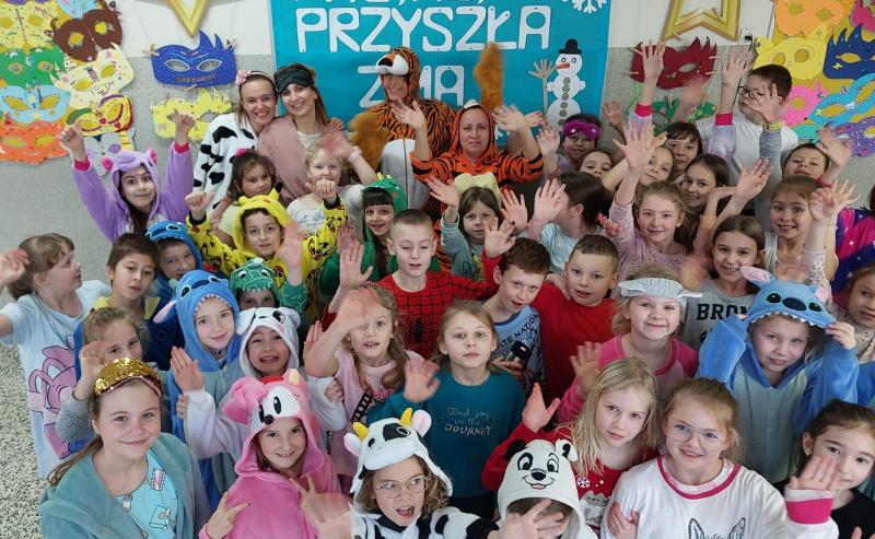 Zdjęcie grupowe z uczniami i pracownikami szkoły w piżamach. Zdjęcie zrobione z wysokości.