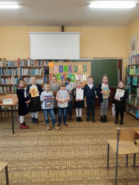 Uczniowie z nagrodami w bibliotece szkolnej.