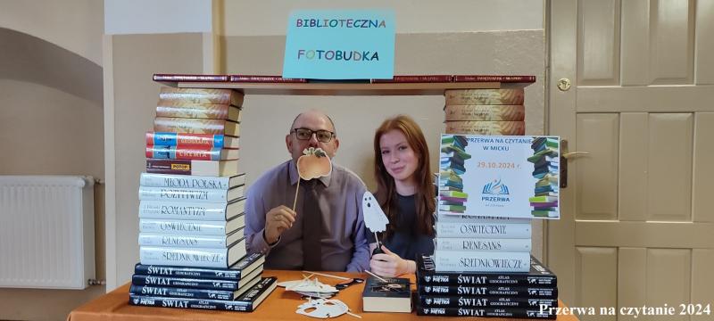 dyrektor z uczennicą w fotobutce z książek