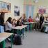 Uczniowie różnych szkół w ławkach sali językowej podczas międzyszkolnego quizu wiedzy o krajach anglojęzycznych.