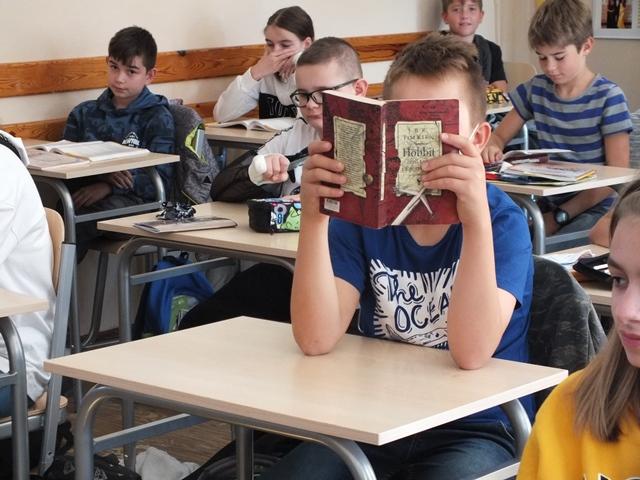 Uczeń klasy 6 czyta lekturę "Hobbit"