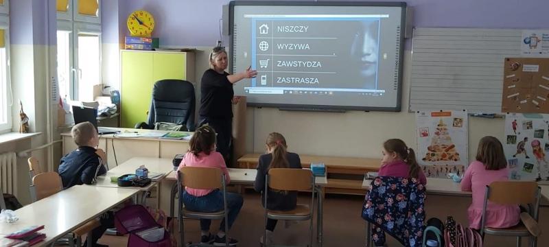 Nauczyciel przedstawia na tablicy multimedialnej prezentację