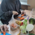 Tutaj jest właśnie Ola ( jedyna dziewczyna w klasie ), która fachowo kroi marchewkę. Na stole leżą słoiki, warzywa (seler naciowy, brokuły, marchewka) , jabłka, zakrętki do słoików, deski do krojenia i obieraczka.