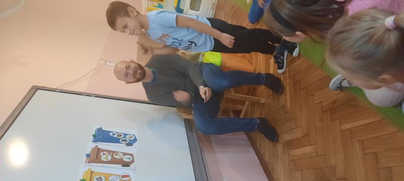 Pracownik PgK pokazuje dzieciom rodzaje śmietników