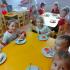 Dzieci siedzące przy stole jedzące ciasto biało czerwone