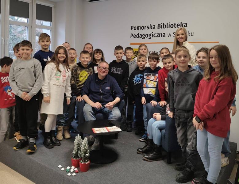 Zdjęcie grupowe uczniów klasy 3a z autorem w bibliotece miejskiej