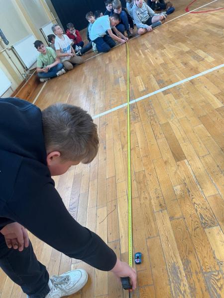 Uczniowie dokonują pomiaru drogi i czasu samochodzika