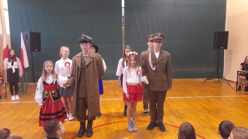 Spektakl teatralno-muzyczny z okazji Dnia Niepodległości. Uczniowie na szkolnej scenie.