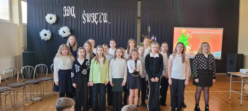 Szkole kolędowanie - uroczystość na sali gimnastycznej szkoły - uczniowie śpiewają kolędę