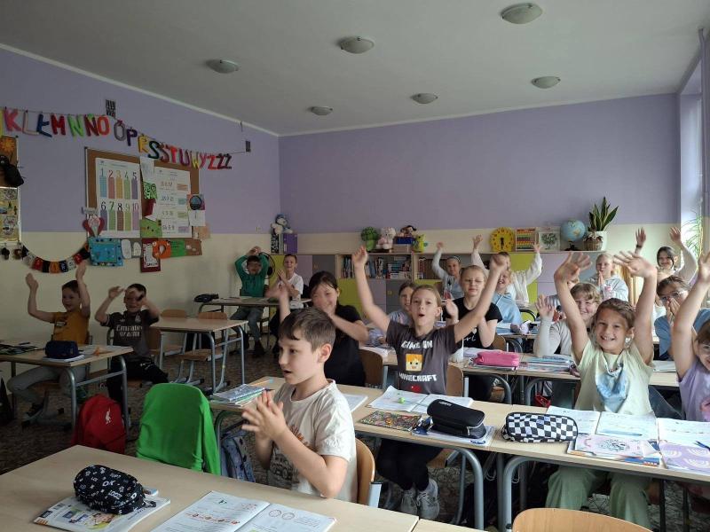 Uczniowie klasy 3a i 3b oglądają na żywo start rakiety Falcon 9 na szkolnej tablicy interaktywnej - zdjęcie uczniów w ławkach