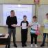 Zdjęcie laureatów quizu z dyrektorem i nauczycielem przez tablicą