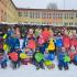 Zdjęcie grupowe dzieci przed budynkiem szkoły w scenerii zimowej