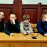 Uczniowie szkoły siedzący w ławach sądu